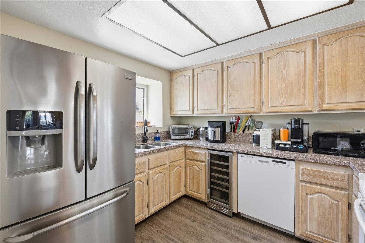6373 Rancho Mission Road, Unit 5 San Diego, CA 92108 - Photo 12 of 30 a kitchen with white cabinets stainless steel appliances and a refrigerator