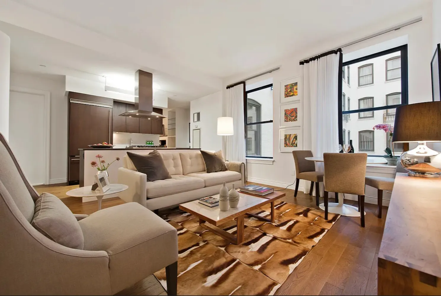 a living room with furniture kitchen view and a window