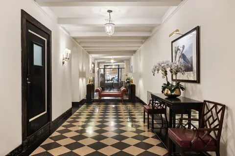 a dining room with chandelier and wooden floor