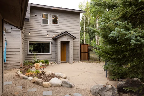 a front view of a house with a large tree and a yard