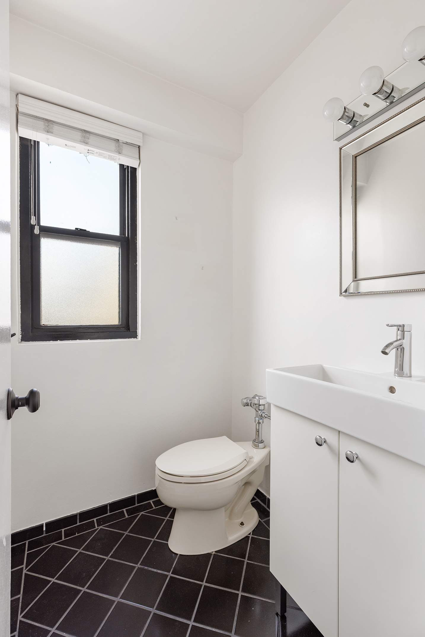 120 East 90th Street, Unit 16E Manhattan, NY 10128 - Photo 9 of 15 a bathroom with a toilet a sink and a mirror
