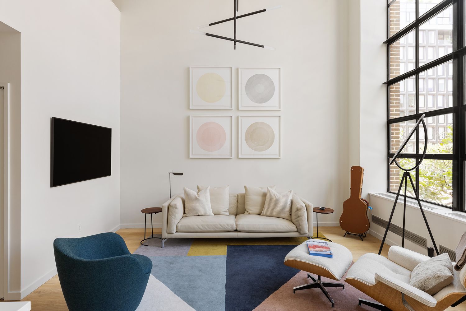 a living room with furniture a flat screen tv and a window