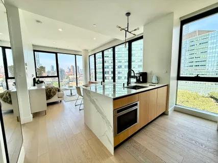 a kitchen with stainless steel appliances granite countertop a stove and a large window