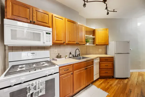 a kitchen with stainless steel appliances granite countertop a stove a sink and a microwave