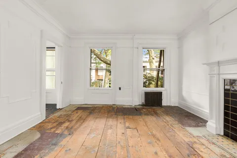 a view of a livingroom with wooden floor and white walls