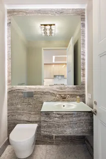 a bathroom with a toilet sink and mirror