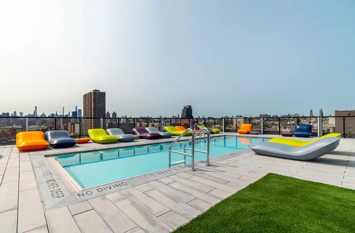 158 East 126th Street, Unit 730 Manhattan, NY 10035 - Photo 9 of 18 an aerial view of a swimming pool with a lounge chairs