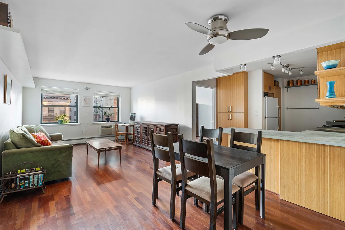a dining room with wooden floor a chandelier fan a wooden table and chairs