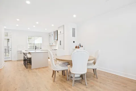 a kitchen with a dining table chairs and white cabinets