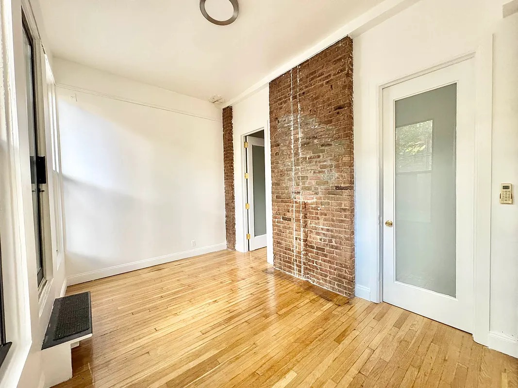 238 Gates Avenue, Unit 2 Brooklyn, NY 11238 - Photo 5 of 13 a view of an empty room with wooden floor and a bathroom