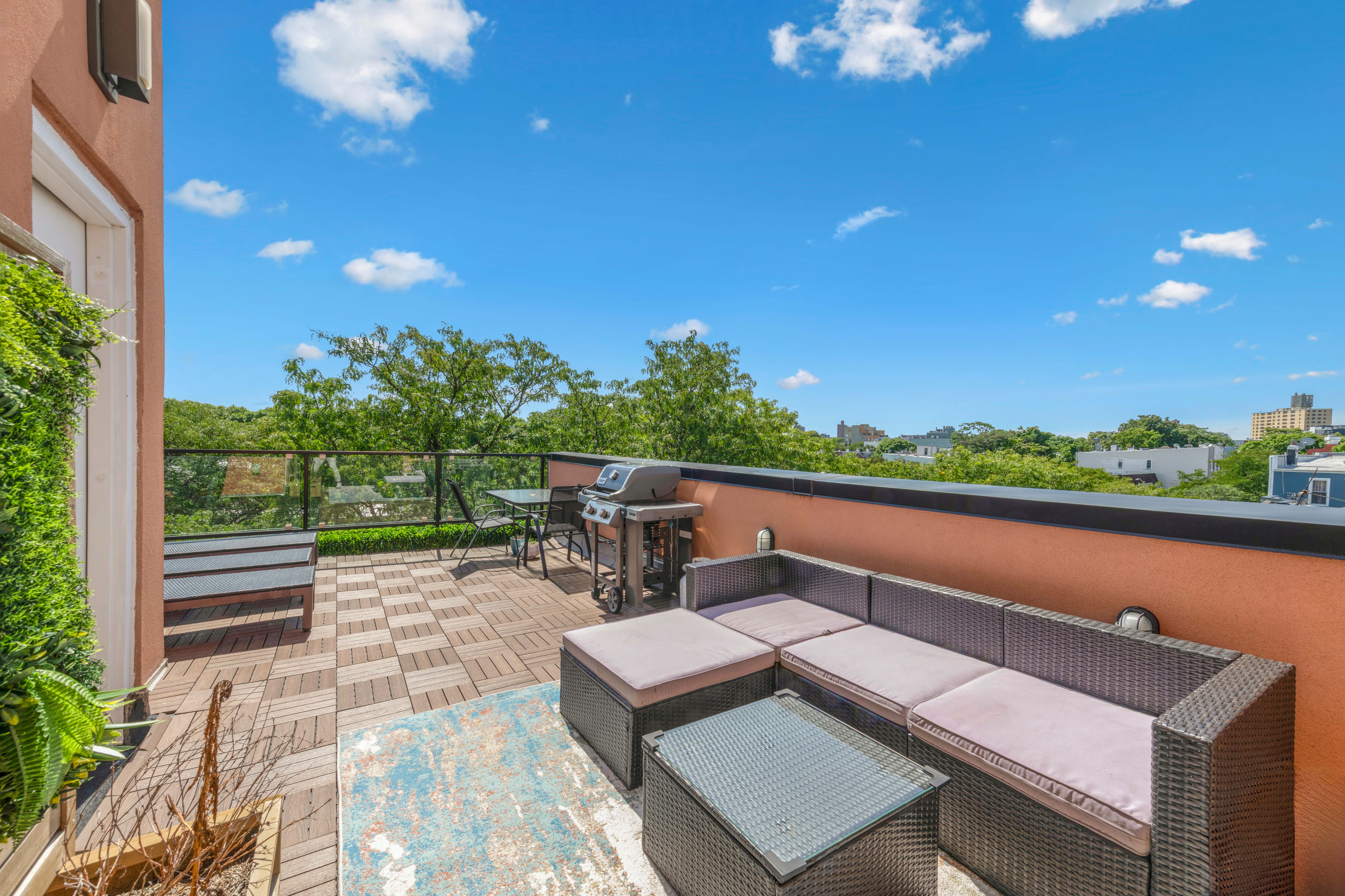 1189 Jefferson Avenue, Unit 2 Brooklyn, NY 11221 - Photo 9 of 10 a roof deck with table and chairs a barbeque with potted plants and large tree