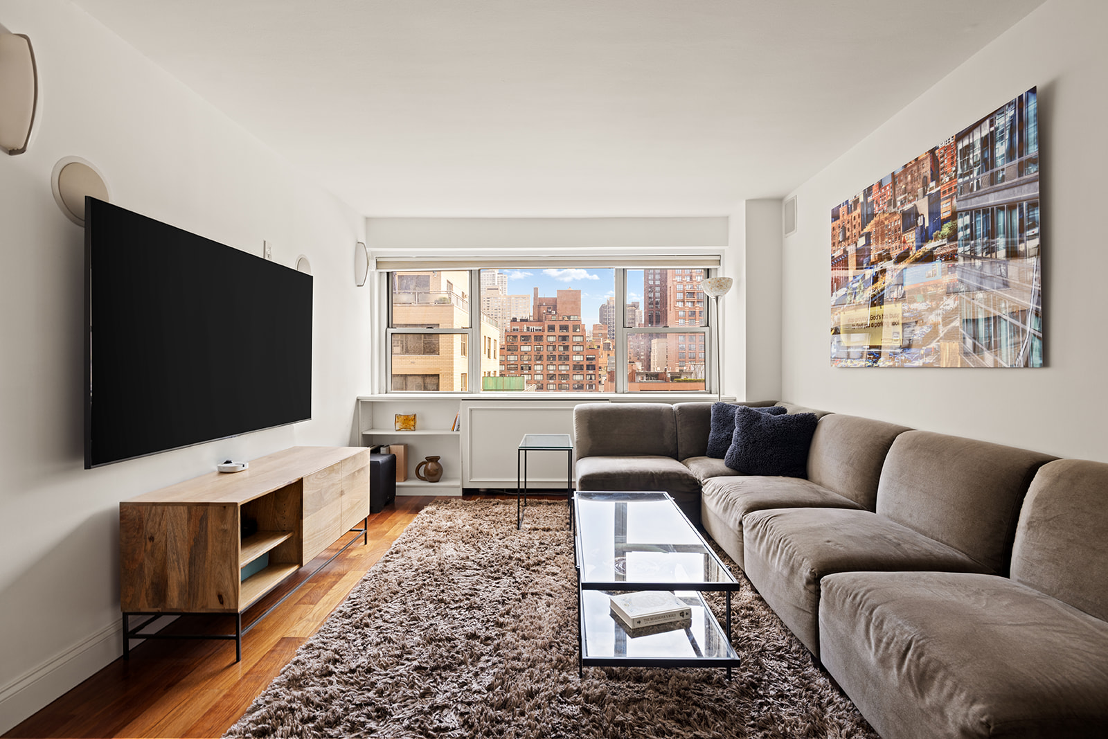 330 East 49th Street, Unit 12E Manhattan, NY 10017 - Photo 7 of 16 a living room with furniture and a flat screen tv