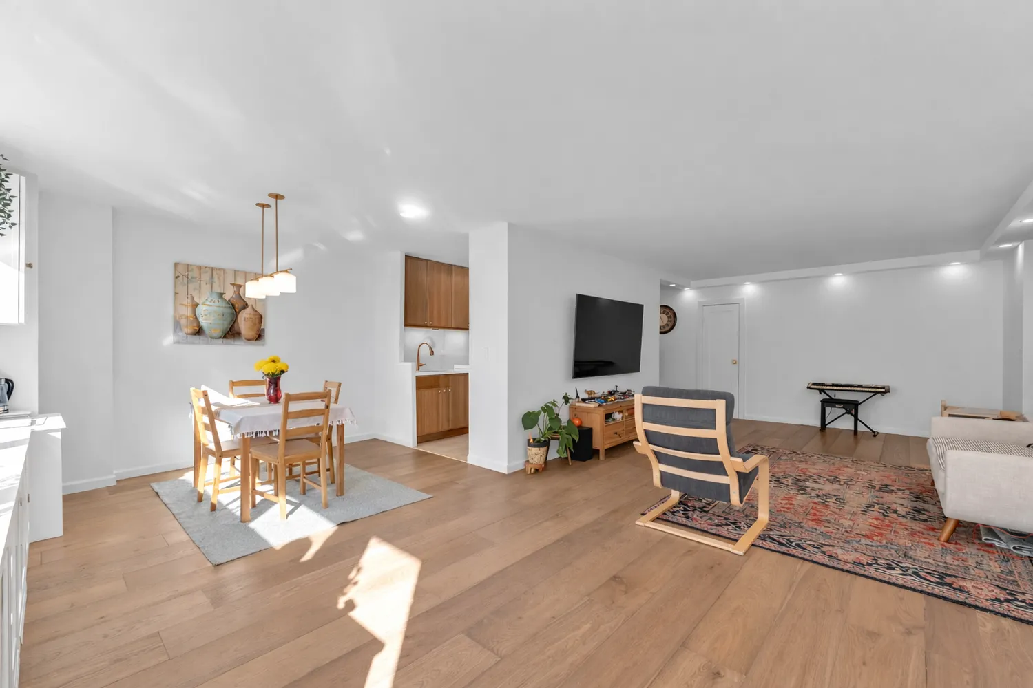 a living room with furniture a flat screen tv and kitchen view