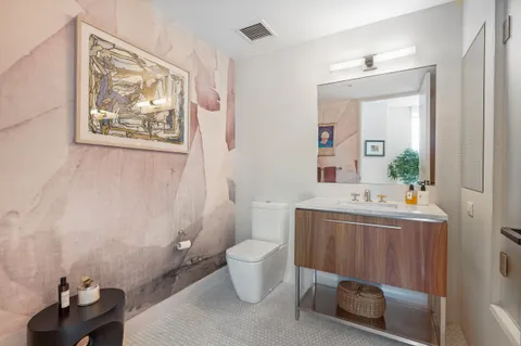 a bathroom with a sink mirror and toilet