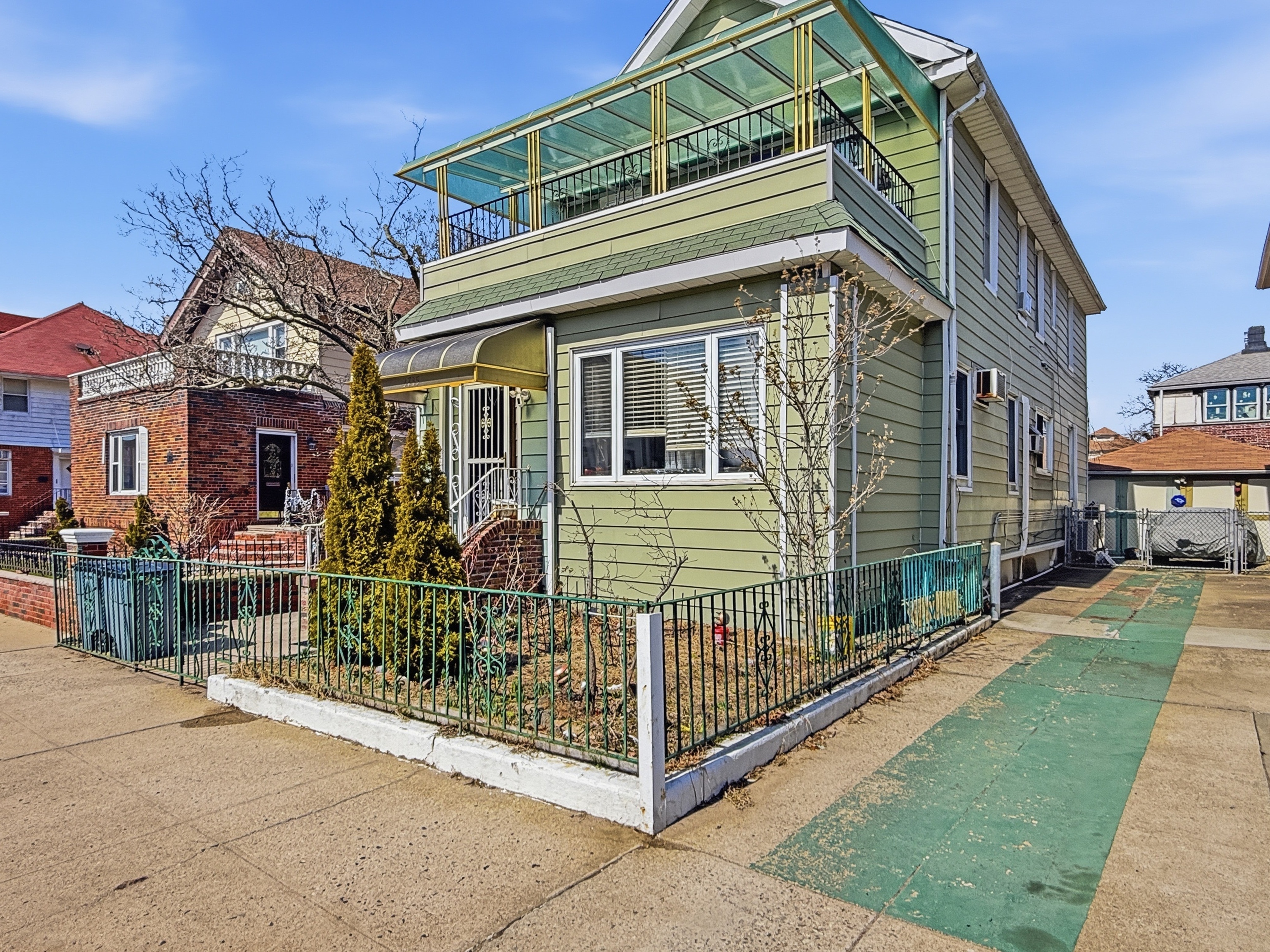 a view of a house with a small yard and wooden fence