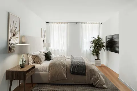 a bedroom with a bed and a potted plant