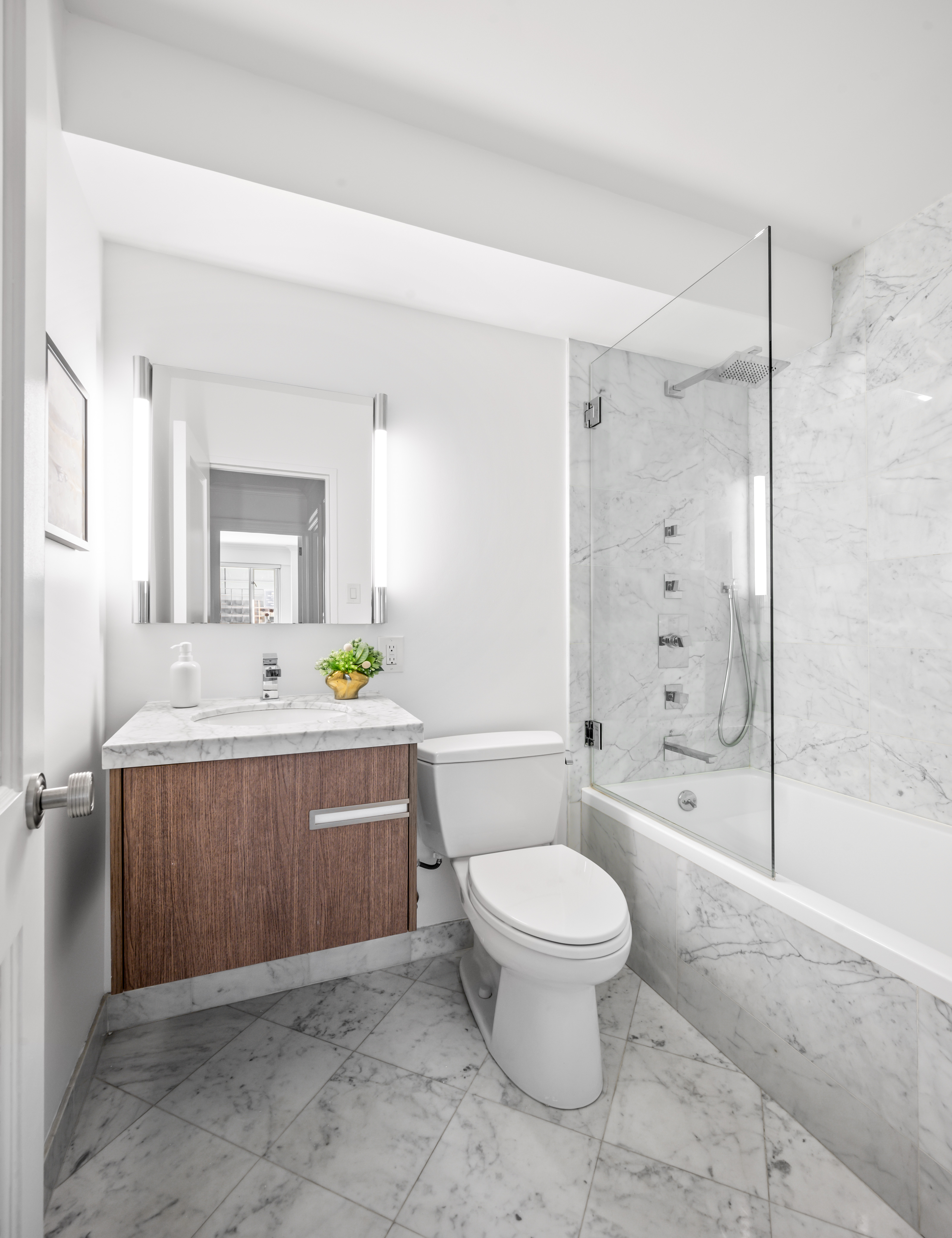166 East 63rd Street, Unit 2J Manhattan, NY 10065 - Photo 13 of 14 a spacious bathroom with a sink toilet and shower