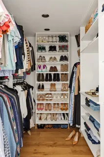 a view of walk in closet with clothes and shoes