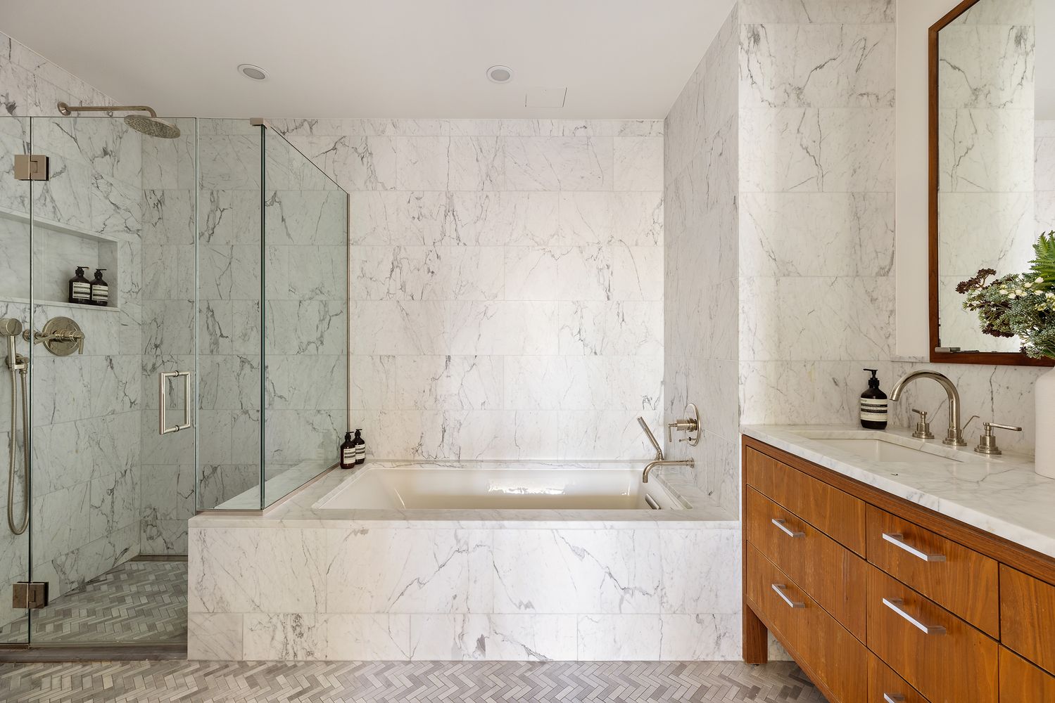 a bathroom with a granite countertop sink a mirror and shower