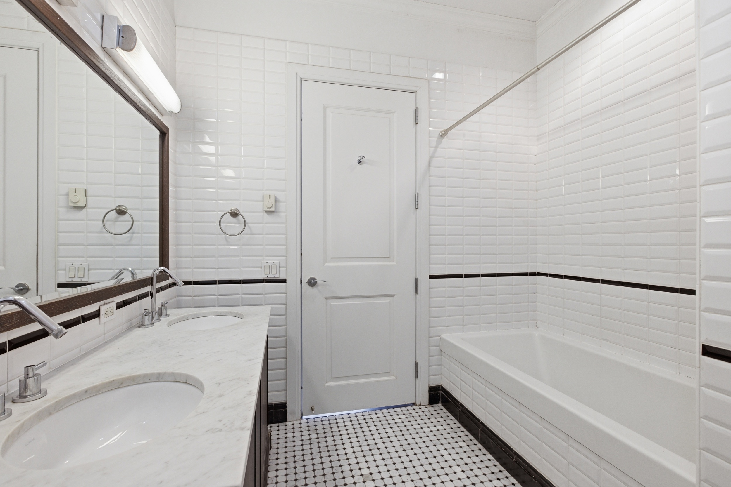 655 6th Avenue, Unit 3D Manhattan, NY 10010 - Photo 13 of 20 a bathroom with a granite countertop sink a mirror and a bathtub