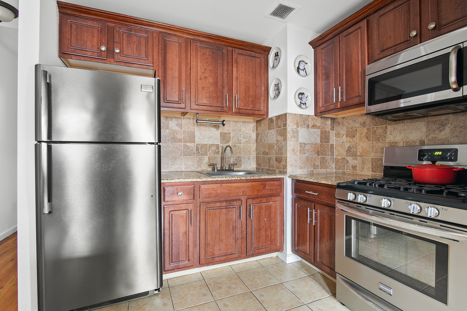 660 St Nicholas Avenue, Unit 54 Manhattan, NY 10030 - Photo 4 of 9 a kitchen with stainless steel appliances granite countertop a refrigerator stove a sink dishwasher and microwave oven