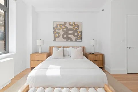 a bed room with a bed and a painting on the wall