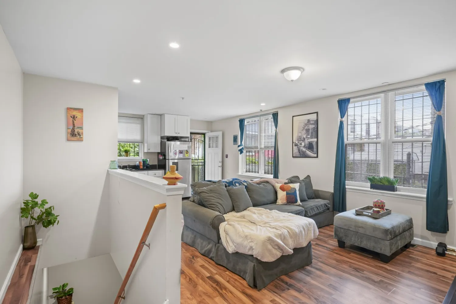 a living room with furniture kitchen view and a large window