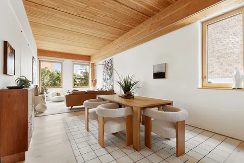 a living room with furniture a window and a potted plant