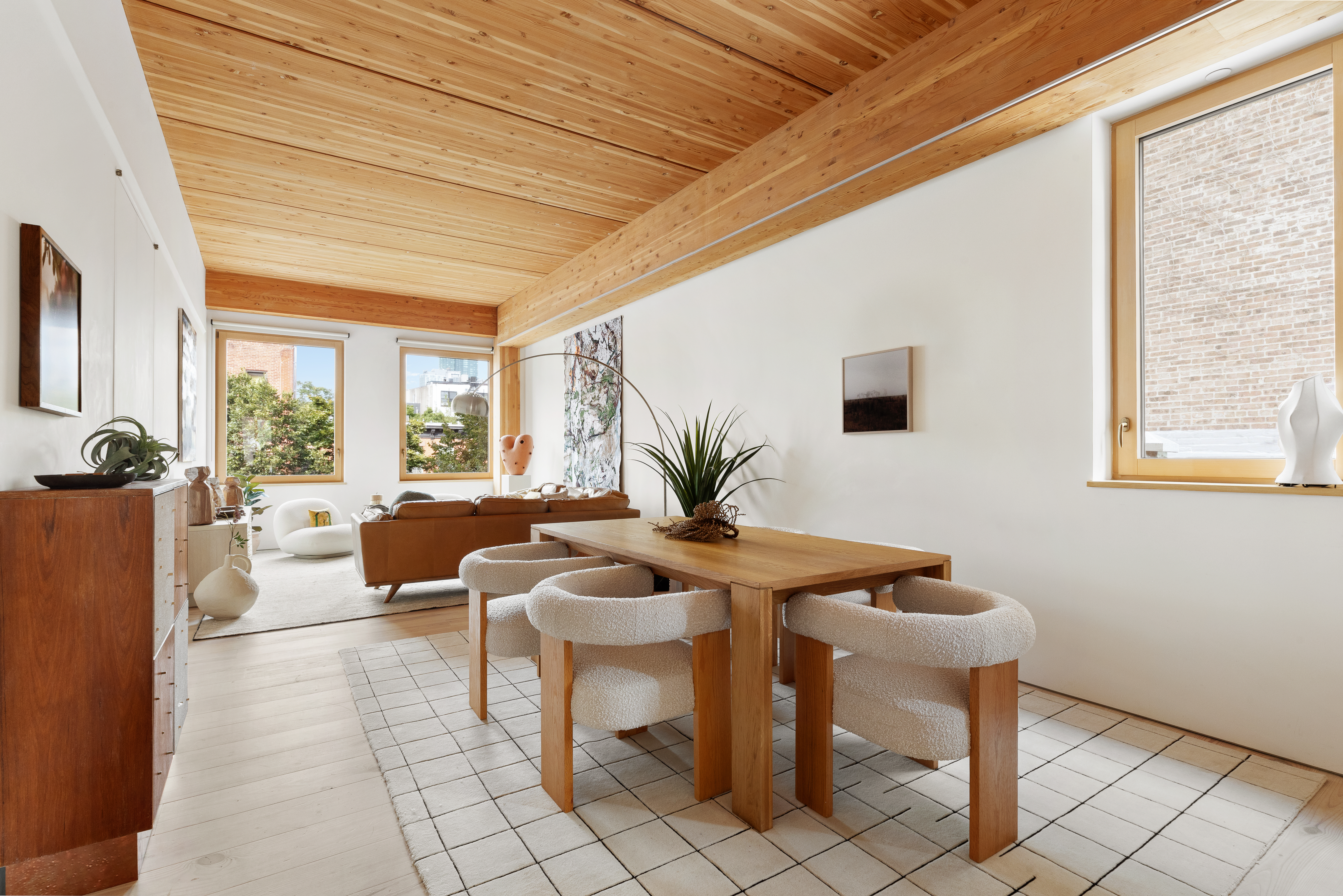 a living room with furniture a window and a potted plant