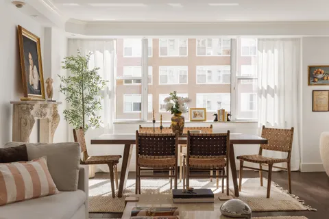 a dining room with furniture and large windows