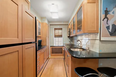 a kitchen with sink a refrigerator and cabinets