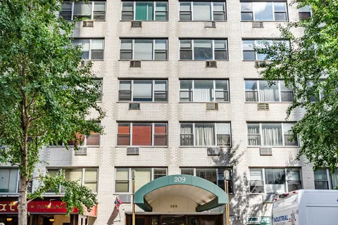 a view of a building with a couple of cars parked in front of a building