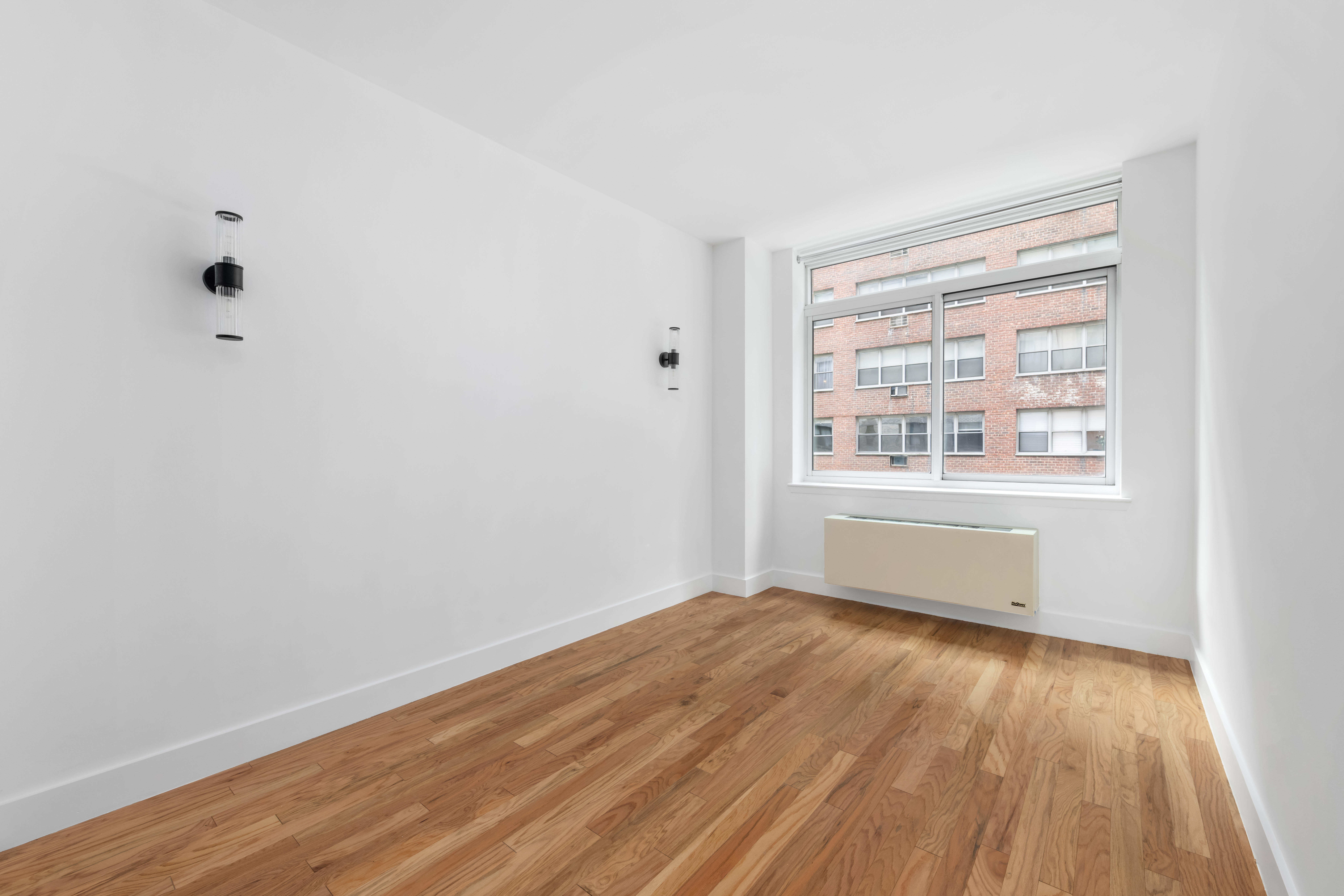 212 East 57th Street, Unit 3B Manhattan, NY 10022 - Photo 4 of 17 a view of an empty room with wooden floor and a window