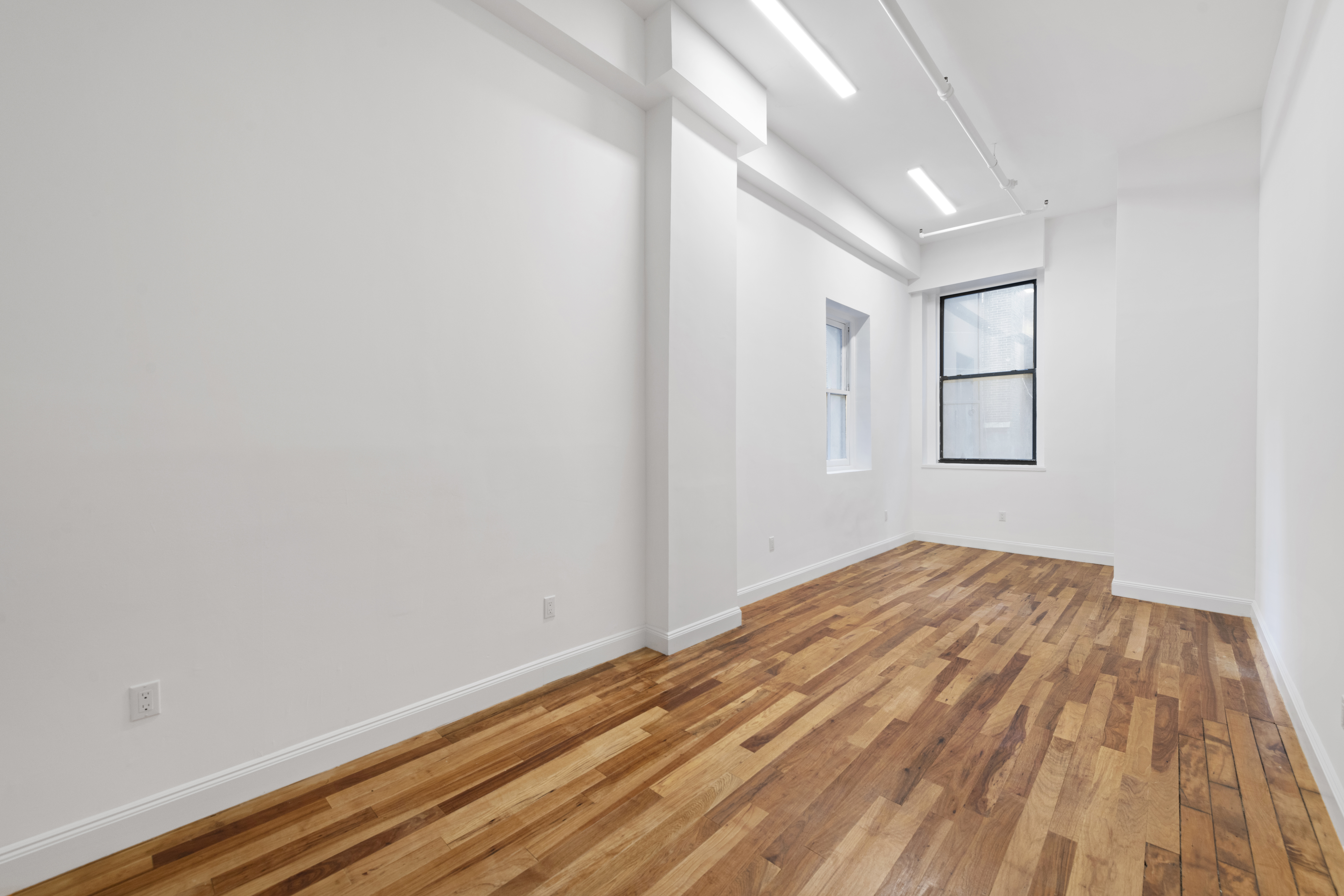 49 Walker Street, Unit 2B Manhattan, NY 10013 - Photo 5 of 7 a view of empty room with wooden floor and fan