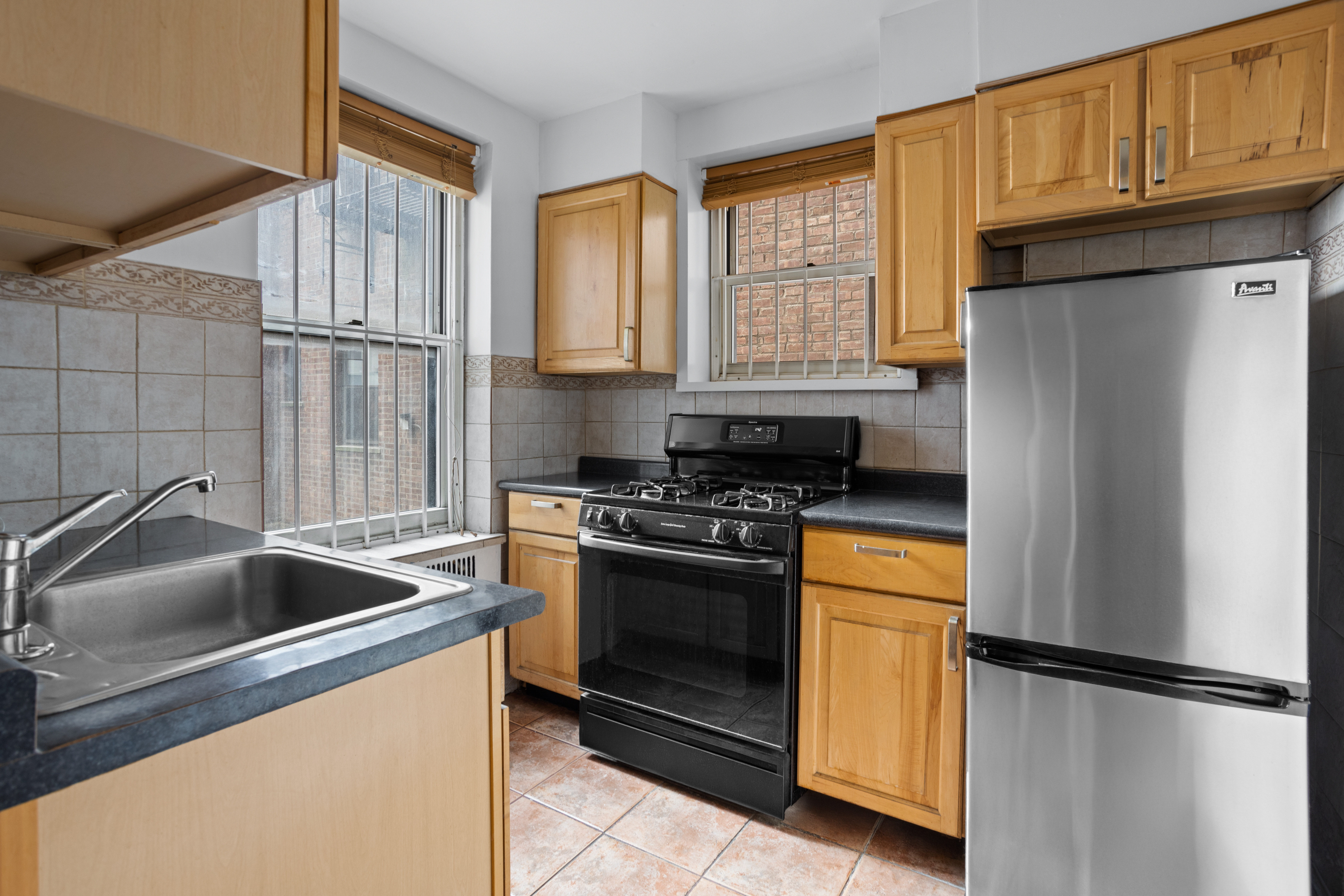 61-41 Saunders Street, Unit A18 Queens, NY 11374 - Photo 2 of 11 a kitchen with a refrigerator and a sink