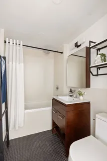 a bathroom with a sink a toilet a mirror and shower