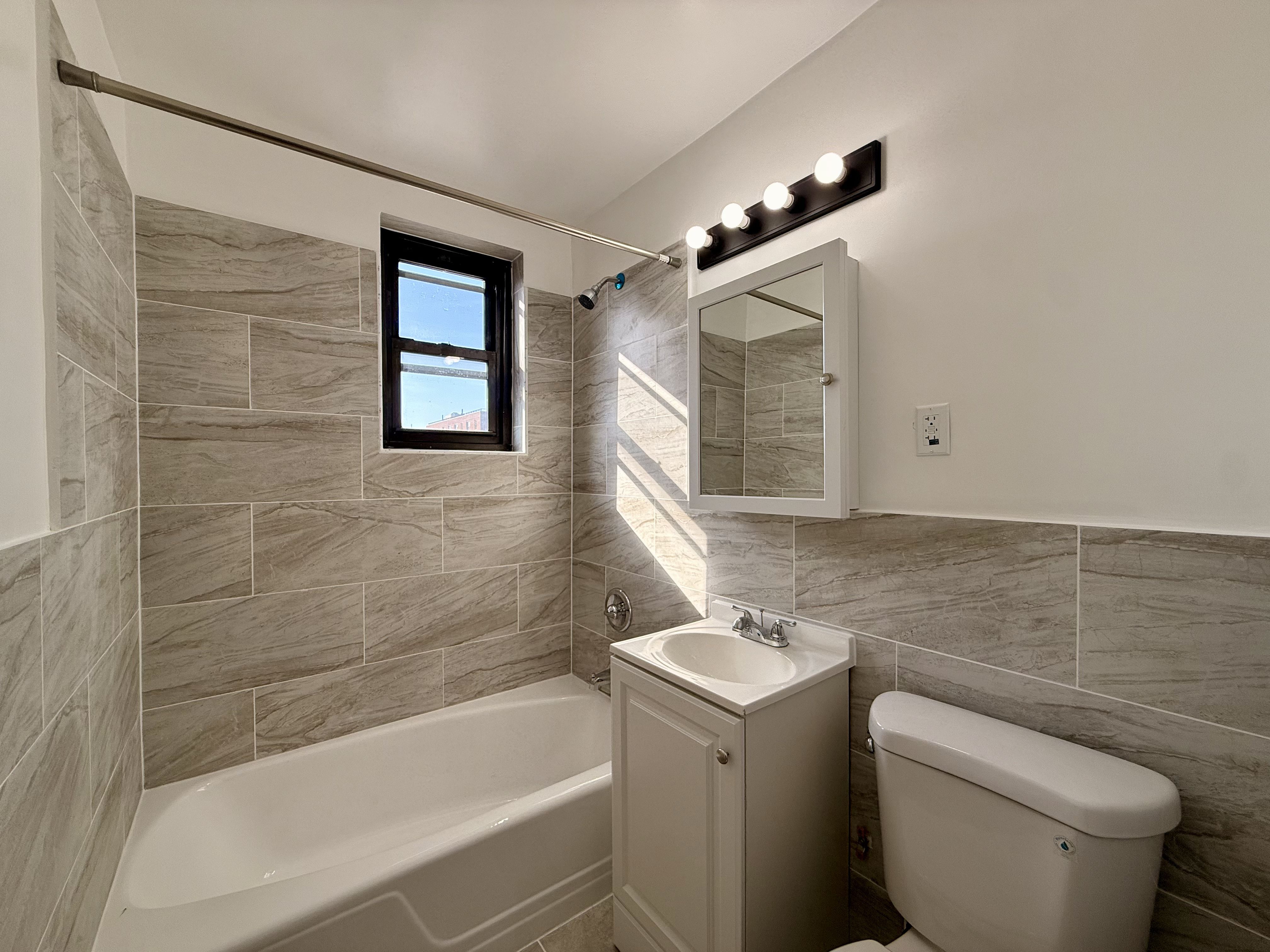 230 73rd Street, Unit 4B Brooklyn, NY 11209 - Photo 6 of 9 a bathroom with a sink a toilet and shower