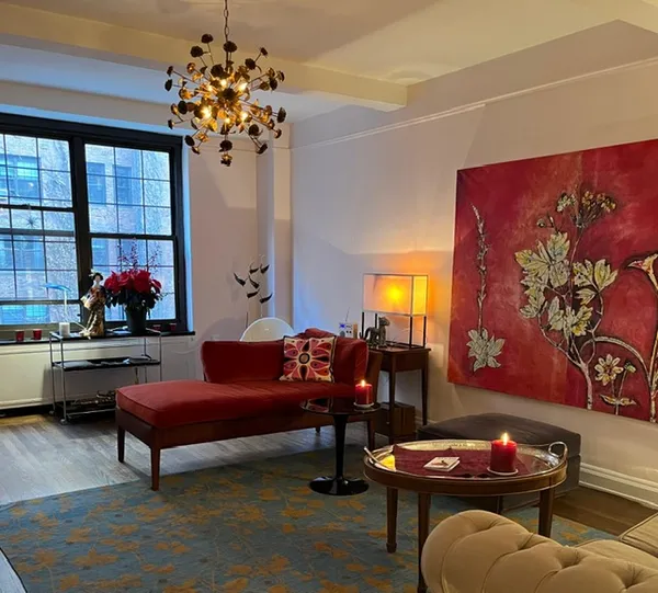 a living room with furniture a chandelier and a potted plant