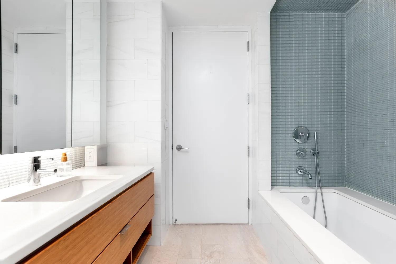 a bathroom with a tub sink and mirror