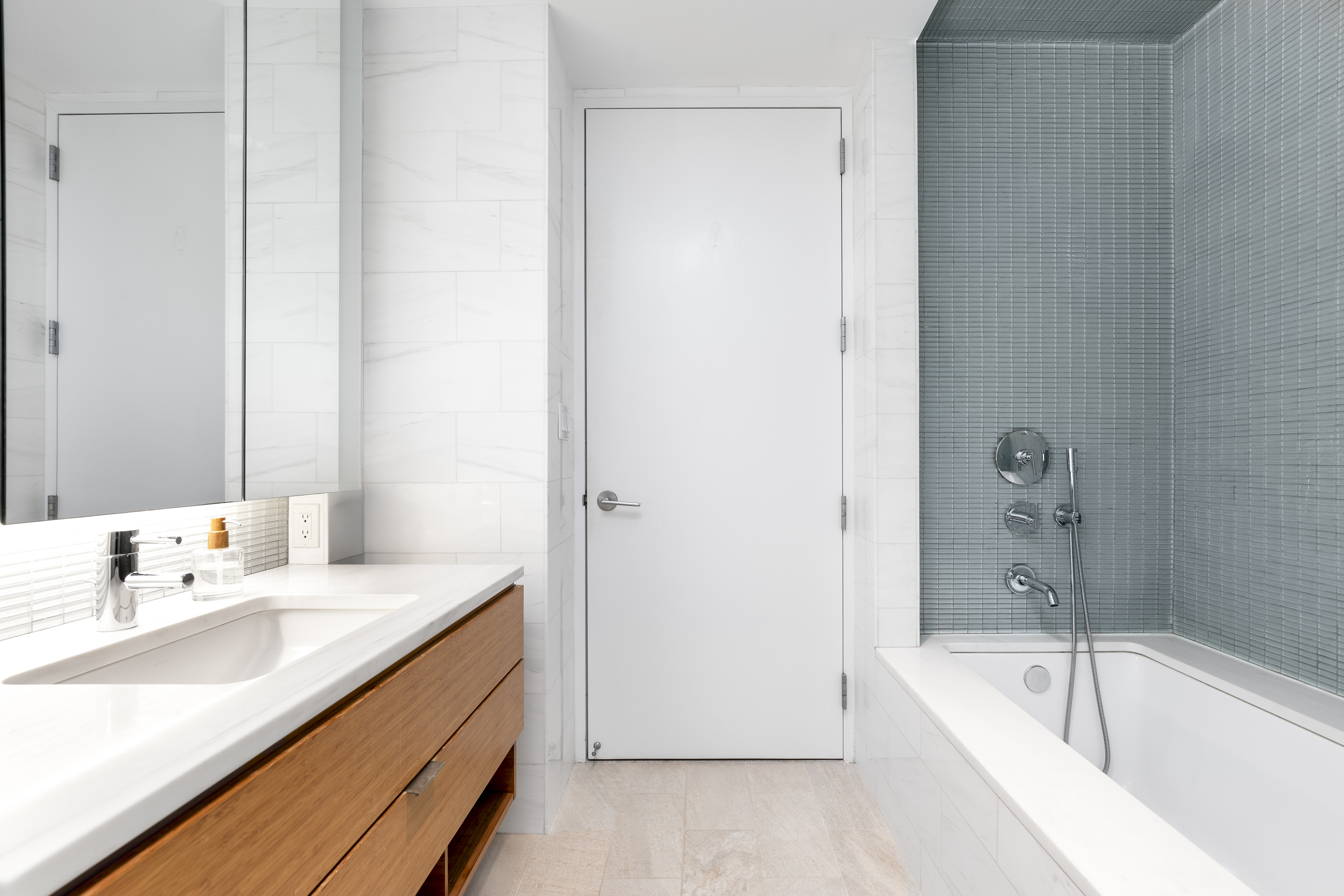 303 East 33rd Street, Unit 7N Manhattan, NY 10016 - Photo 6 of 12 a bathroom with a tub sink and mirror