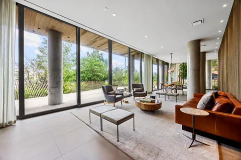a living room with furniture and floor to ceiling windows