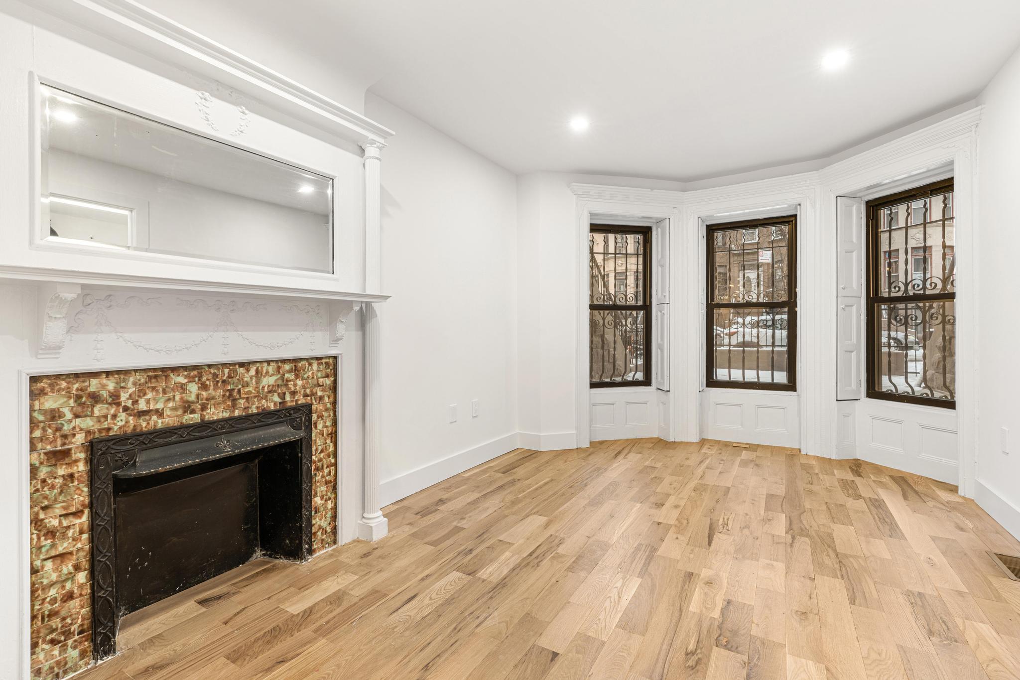 987 Sterling Place Brooklyn, NY 11213 - Photo 10 of 16 a bedroom with a bed and a fireplace