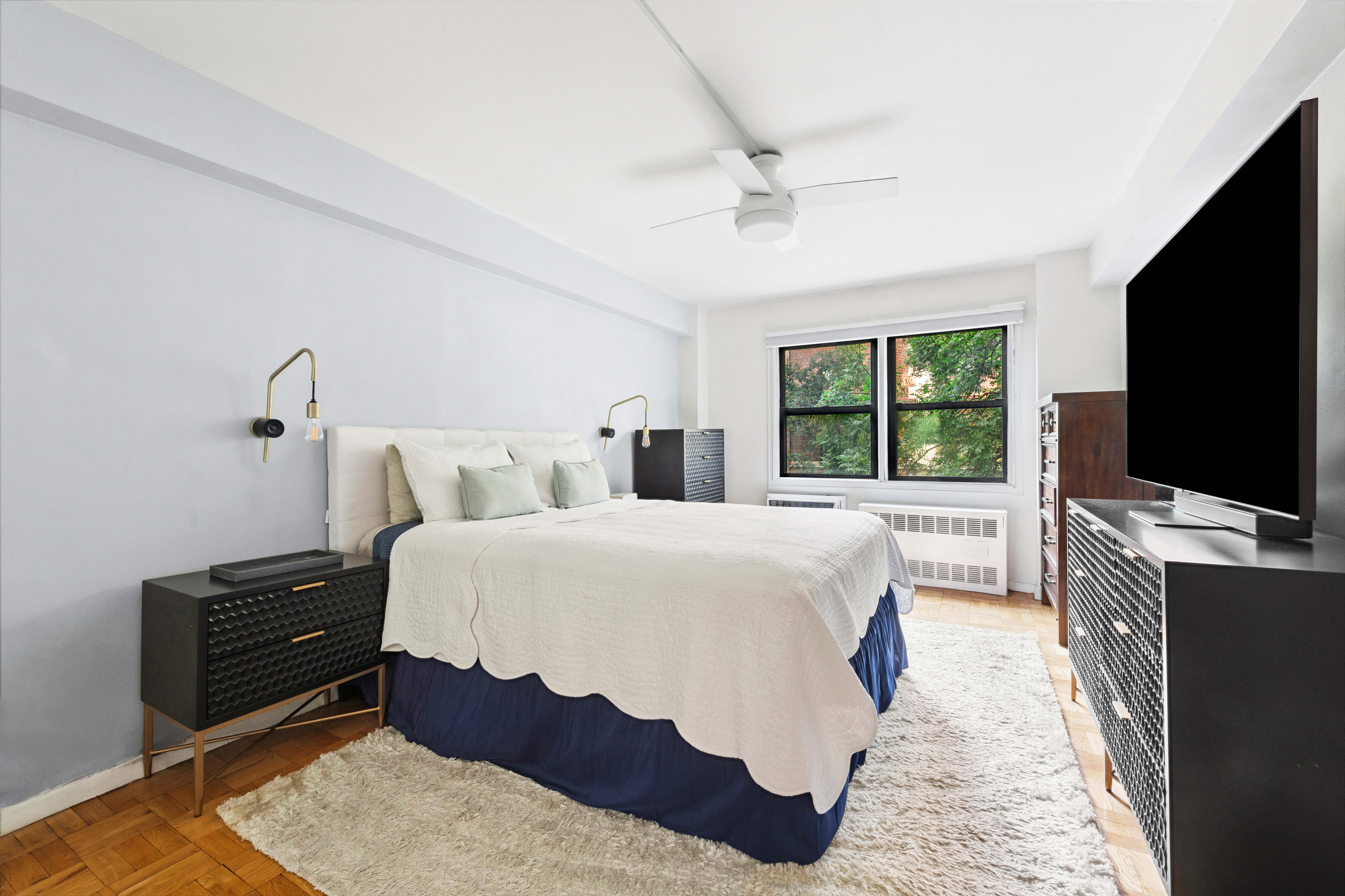 205 East 77th Street, Unit 4B Manhattan, NY 10075 - Photo 7 of 10 a bedroom with a large bed and a flat screen tv