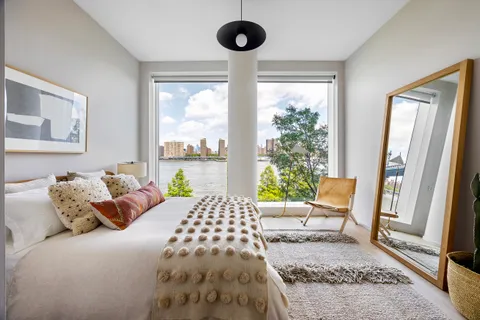 a bedroom with a bed and a large window