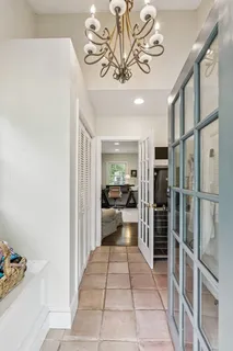 a view of a hallway with furniture and chandelier