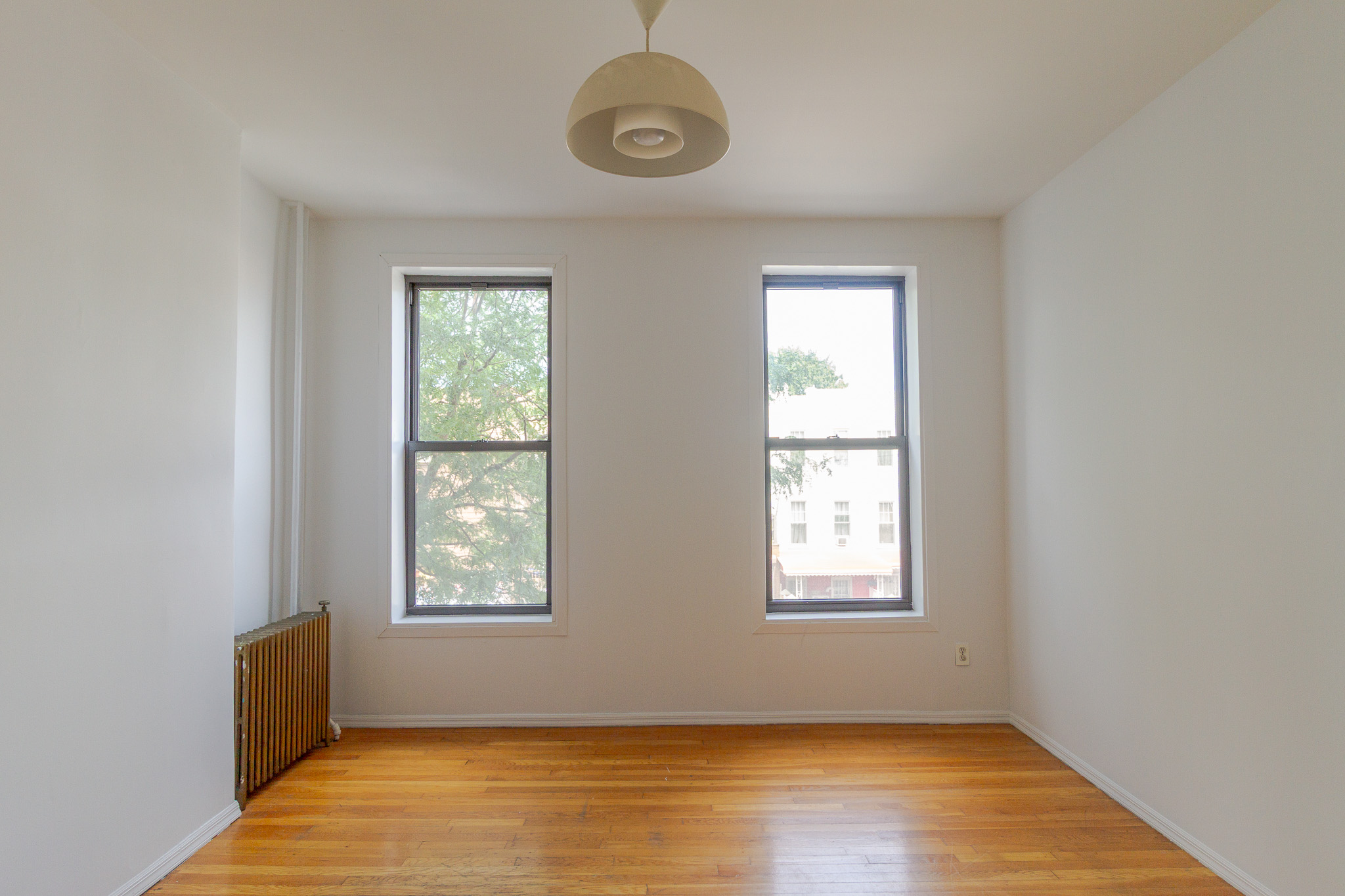 312 Prospect Avenue, Unit 2R Brooklyn, NY 11215 - Photo 1 of 10 a view of an empty room with wooden floor and a window