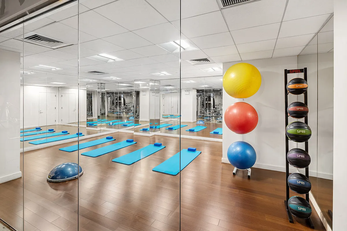 88 Greenwich Street, Unit 1025 Manhattan, NY 10006 - Photo 9 of 14 a kitchen with stainless steel appliances a dining table and chairs