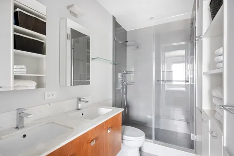 a bathroom with a double vanity sink toilet and shower