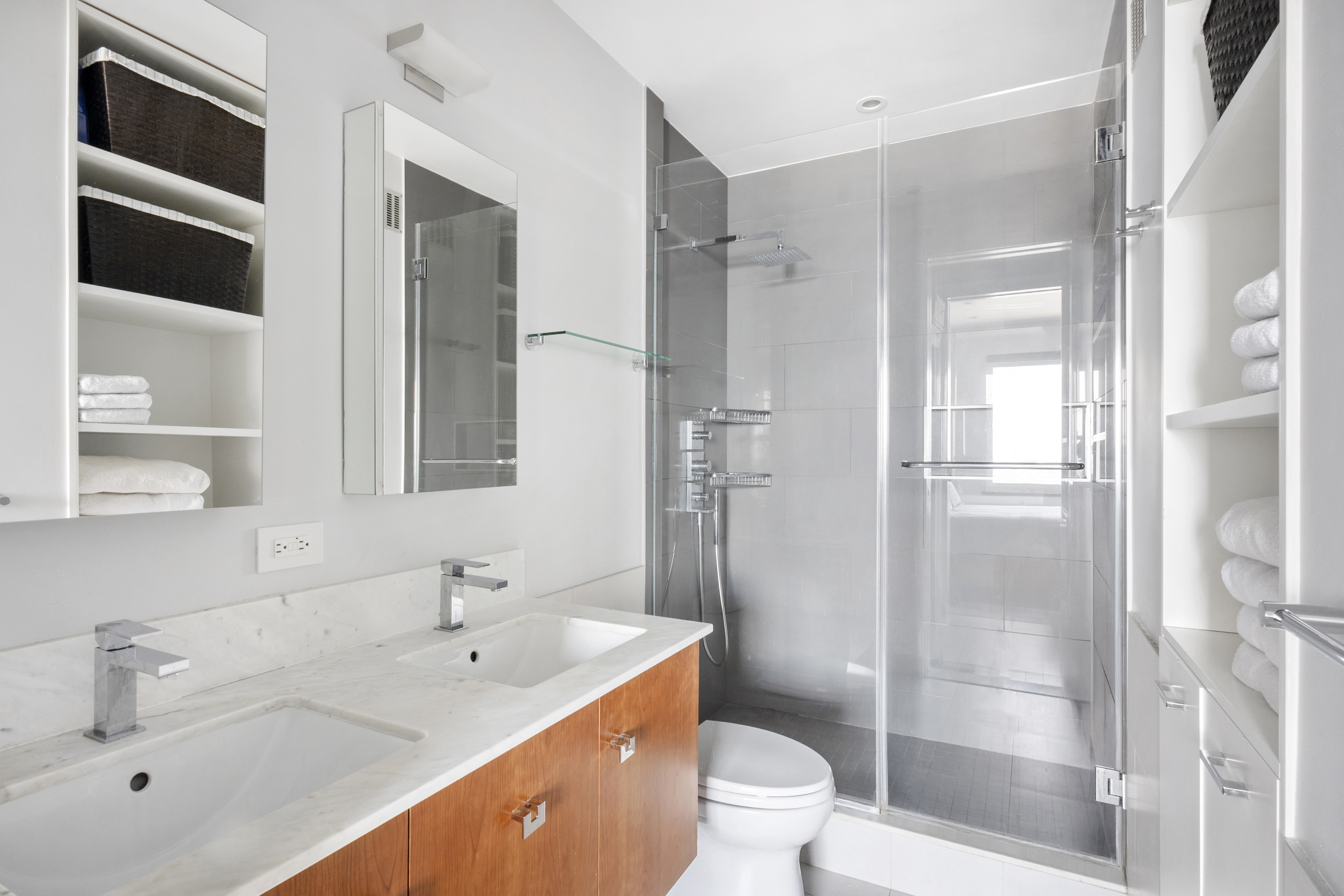 350 West 50th Street, Unit PH4B Manhattan, NY 10019 - Photo 9 of 18 a bathroom with a double vanity sink toilet and shower