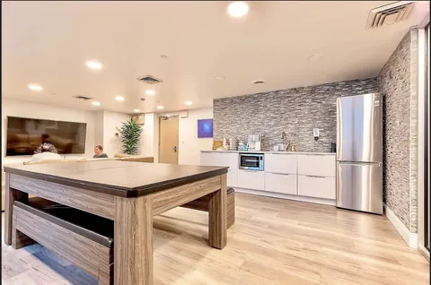 a kitchen with stainless steel appliances kitchen island a hardwood floor and a sink